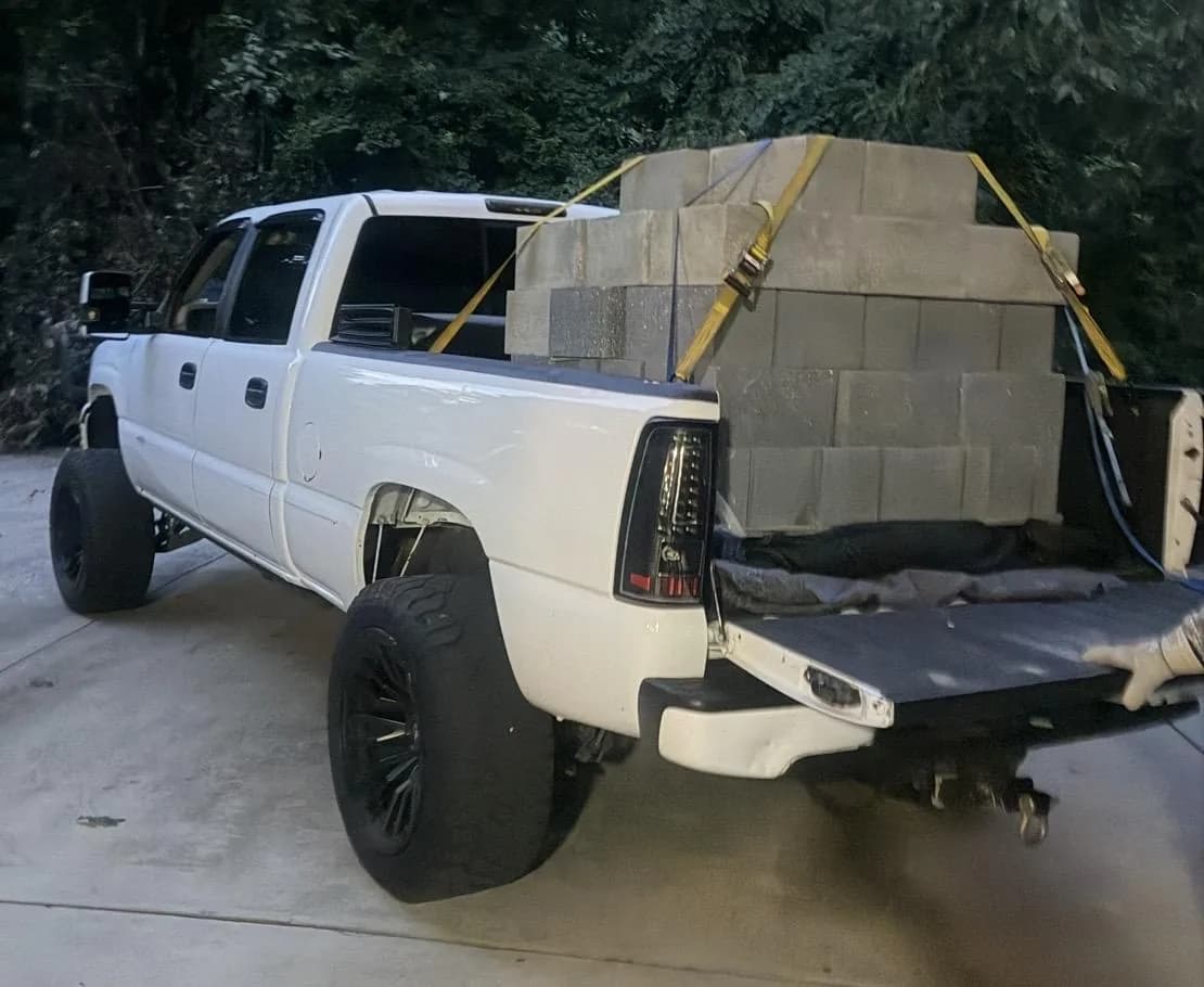 Pickup bed stacked and strapped with 65 heavyweight concrete blocks, 4,000 pounds in one load